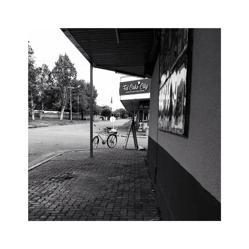 A bicycle standing outside a cafe.