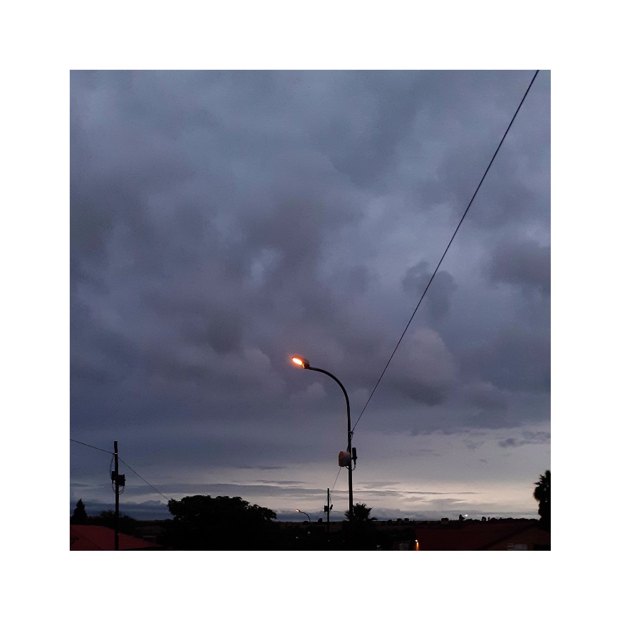 A street lamp against a sky full of dark clouds.