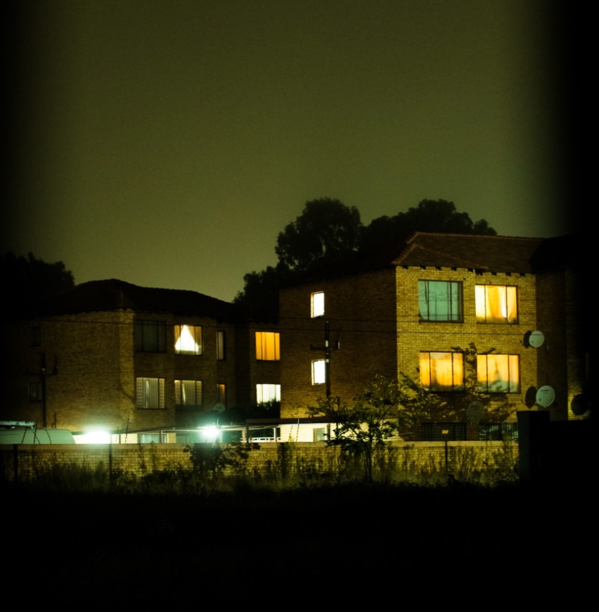 An apartment block at night.
