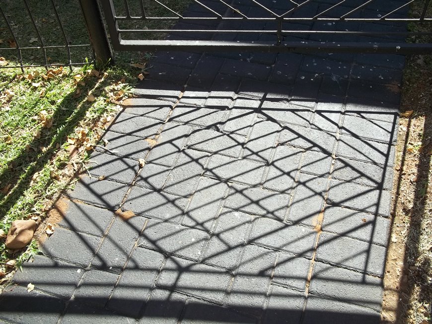 A photo of a shadow pattern on a gate.