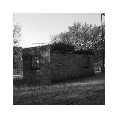 A brick building behind a  fence.