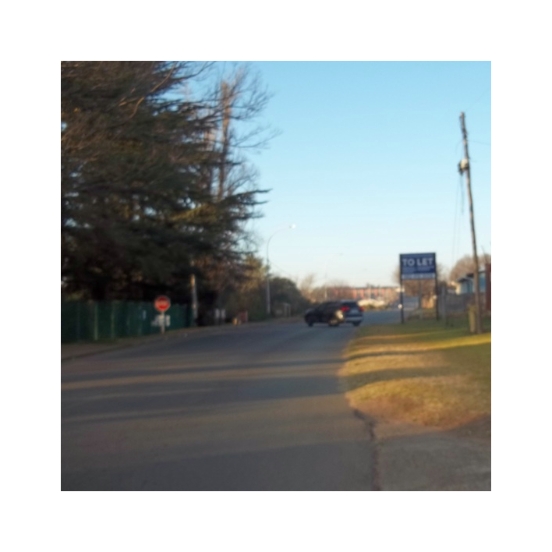 A blurry photograph of a sign and a car.