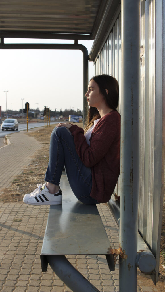 A photo of a woman posing at a bus stop in the West Rand of Gauteng.