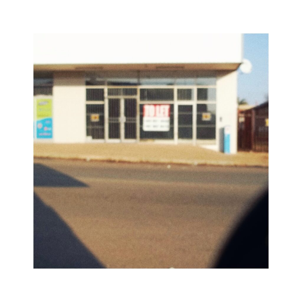 To Let. A blurry image of a sign in a shop window.