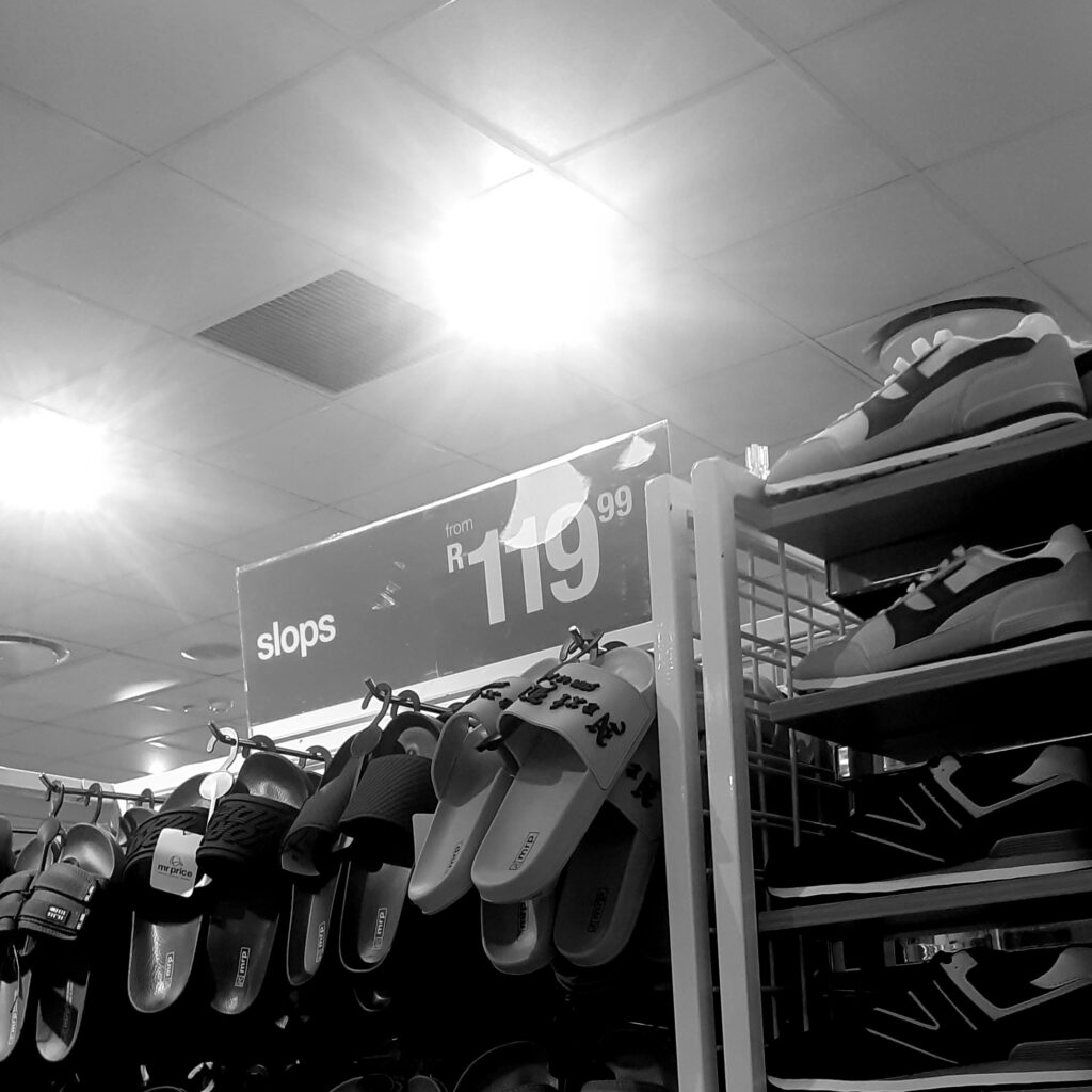 A sign indicating the price of sandals.