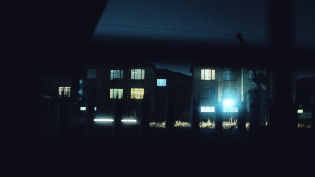 A photograph of a block of apartments at night time.