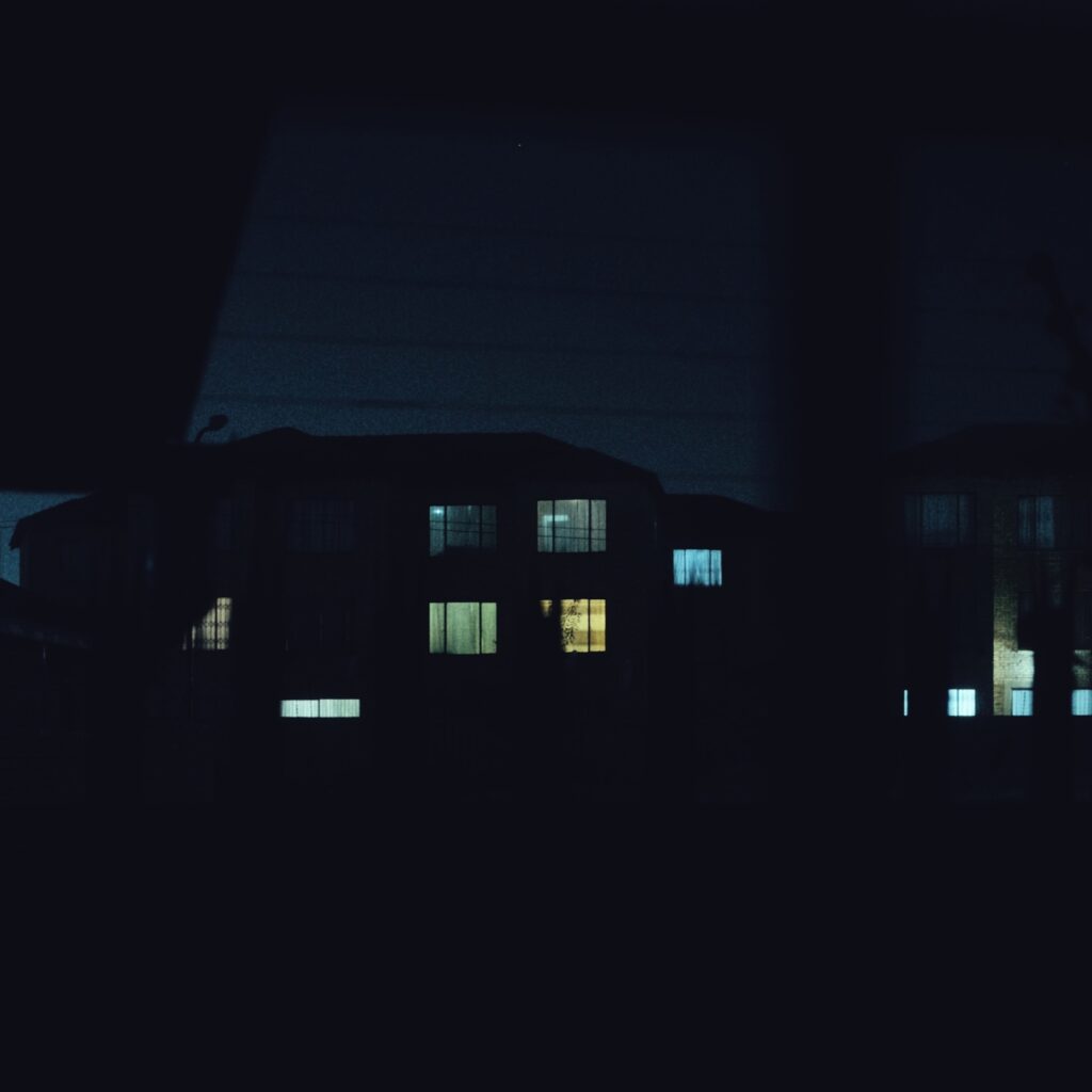 A photograph of a block of apartments at night time.