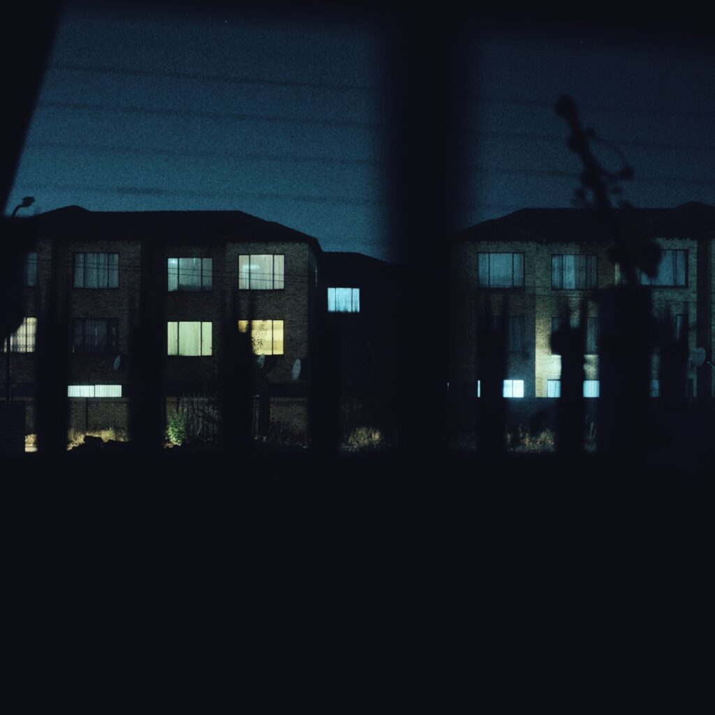 A photograph of a block of apartments at night time.