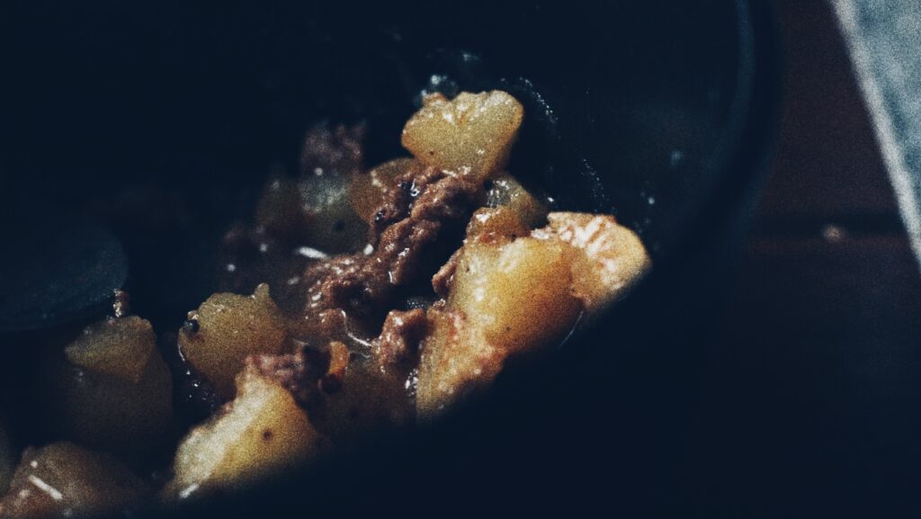 A photograph of a simple ground beef dish with potatoes and baked beans.