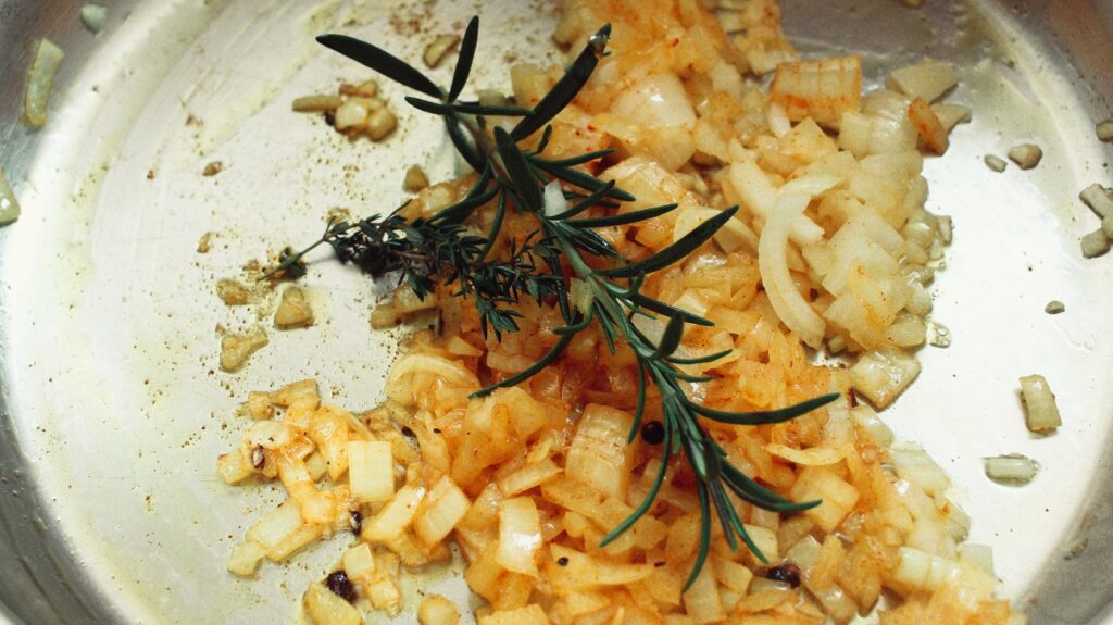Photo of onions being fried in a pan.